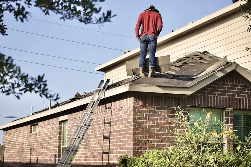 Professional roofer working on a residential roof in Ray